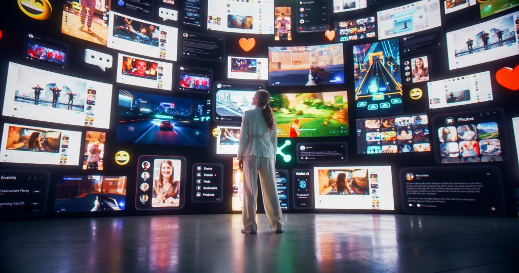 A woman stands in front of a large display featuring multiple smaller screens showcasing various content